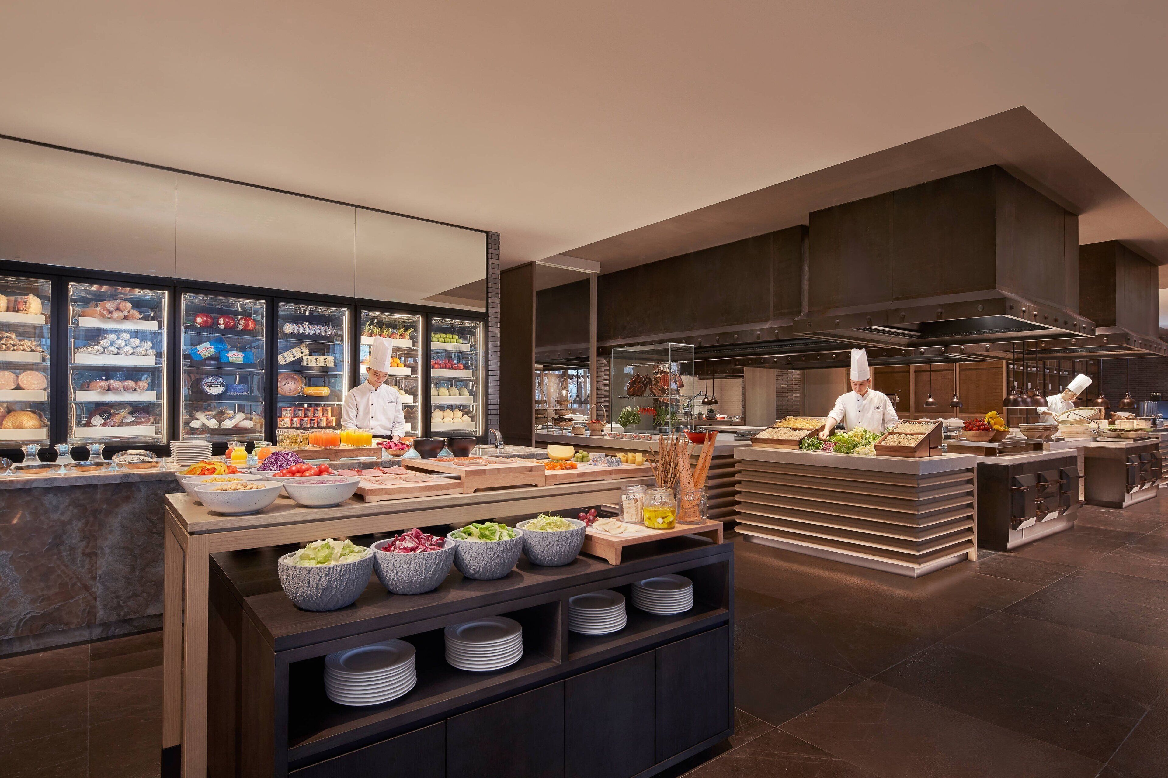 A buffet setup with various food items and a chef preparing food.