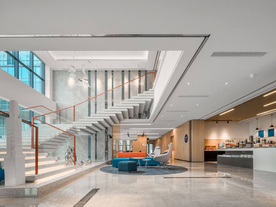 Un vestíbulo amplio con escaleras, zona de estar y área de cocina/salón.