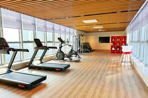 A gym with treadmills, elliptical machines, and weight equipment.
