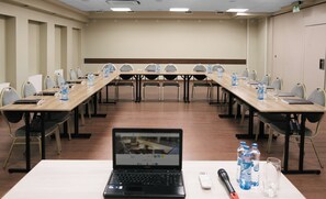 A conference room with a long table, chairs, laptops, water bottles, and a remote control. - Focus Hotel Premium Elbląg (Elblag)