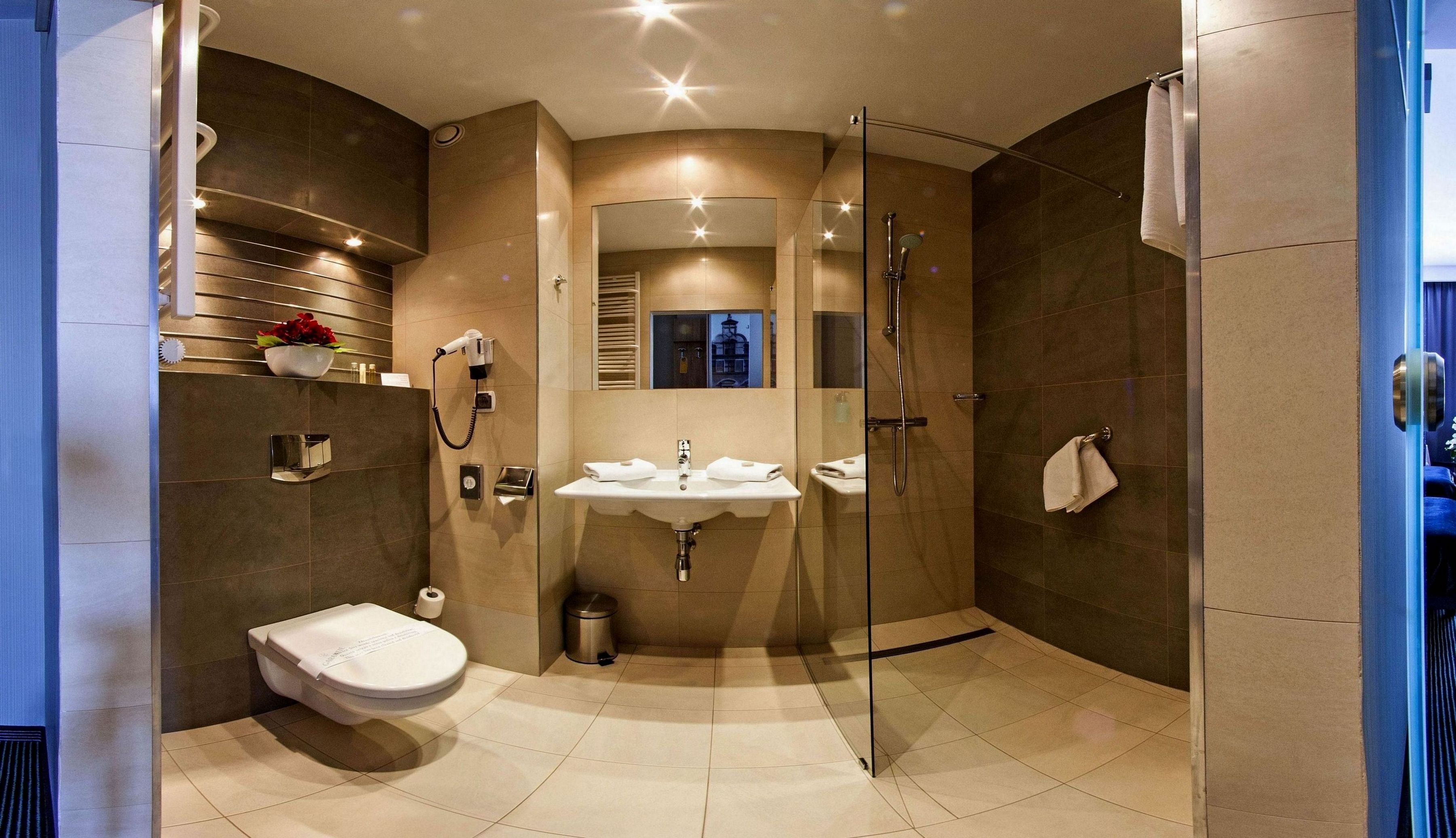 Un baño moderno con inodoro, lavamanos y ducha.