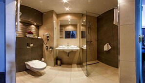 Une salle de bain moderne équipée de toilettes, d’un lavabo et d’une douche.