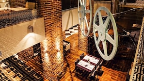 A hotel lobby with a brick column, a checkered floor, and a large metal sculpture. - Focus Hotel Premium Elbląg (Elblag)