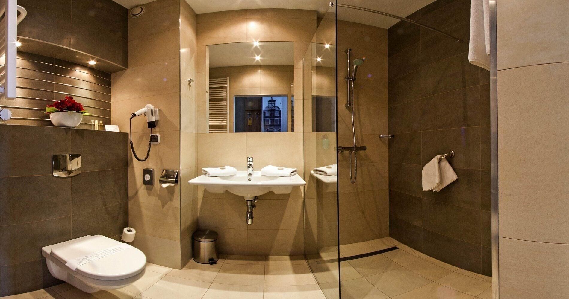 Une salle de bain moderne avec une douche à parois de verre, un lavabo et des toilettes.