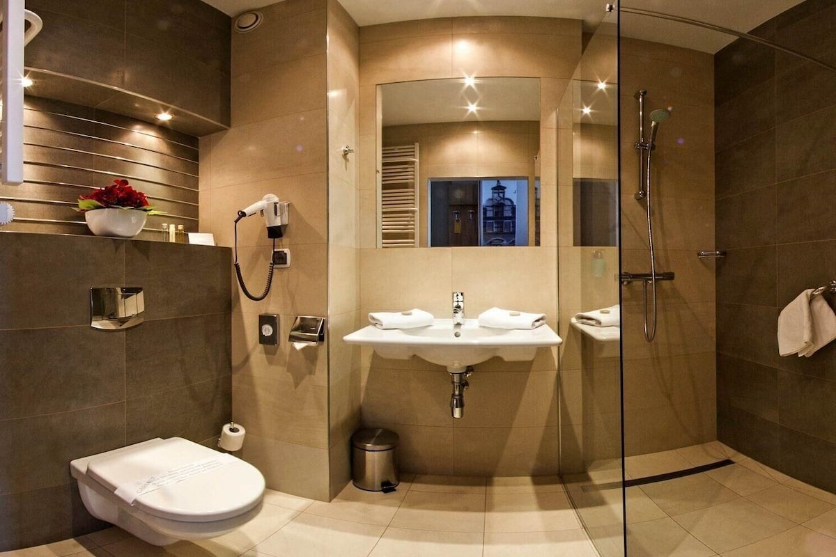 A modern bathroom with a glass-enclosed shower, a sink, and a toilet.