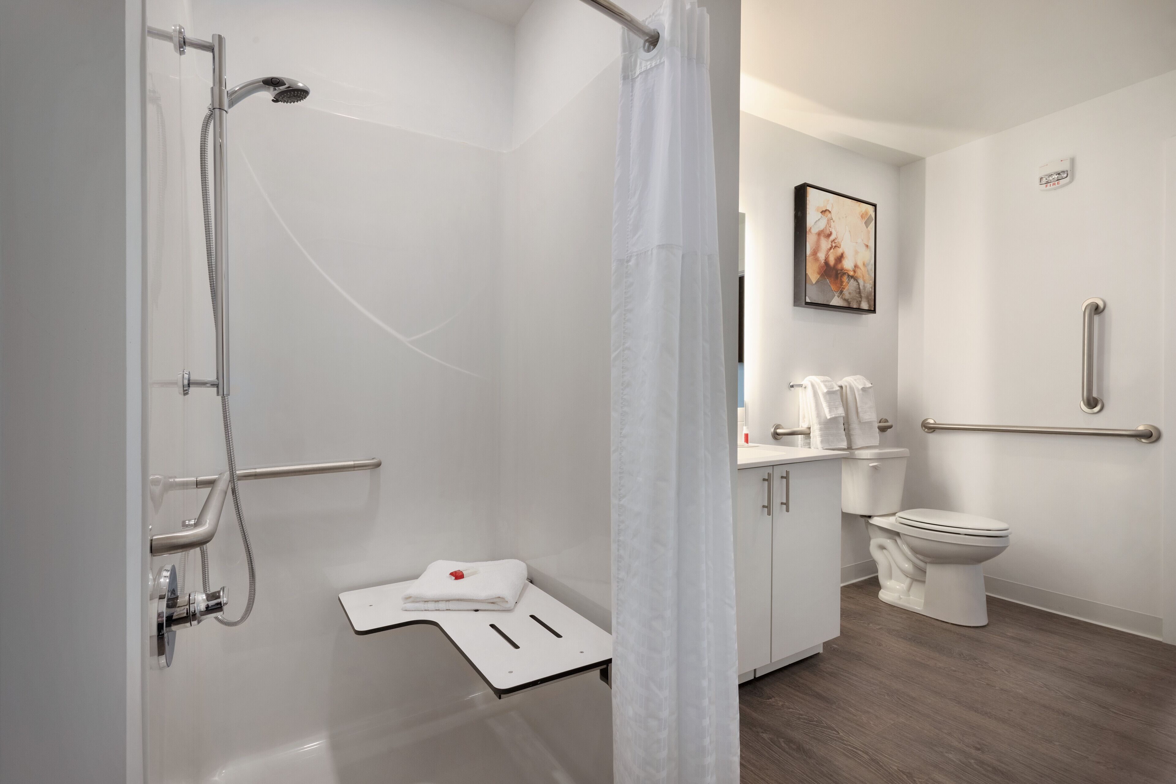 A modern bathroom with a shower, toilet, and sink.