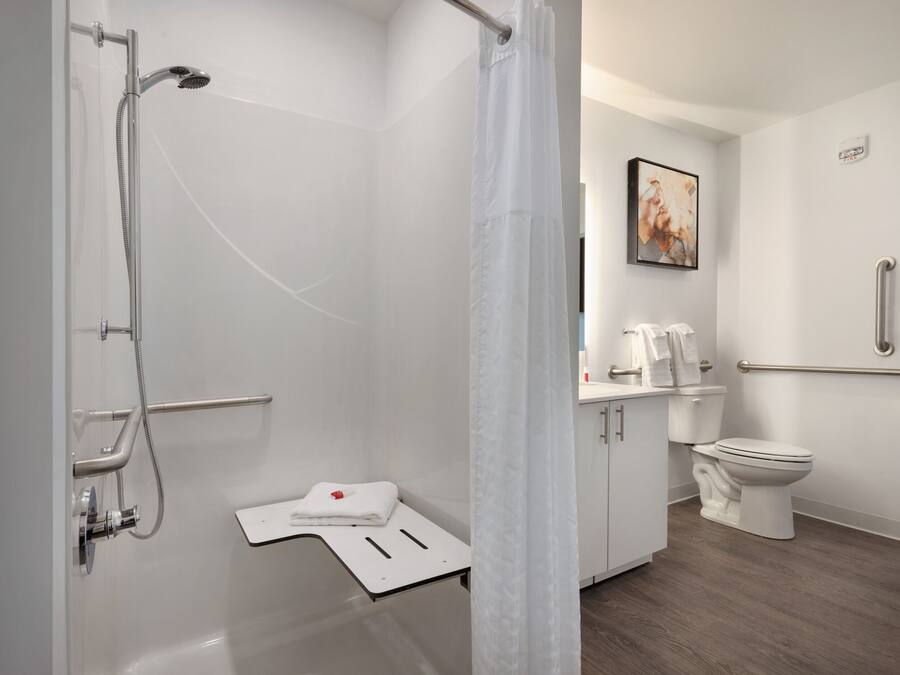 Et moderne badeværelse med bruser, toilet og vask.