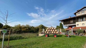 Une maison avec un grand jardin, un camion en bois et un ciel bleu dégagé.