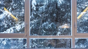 A room with a large window overlooking a snow-covered forest. - Saboredo (Baqueira)
