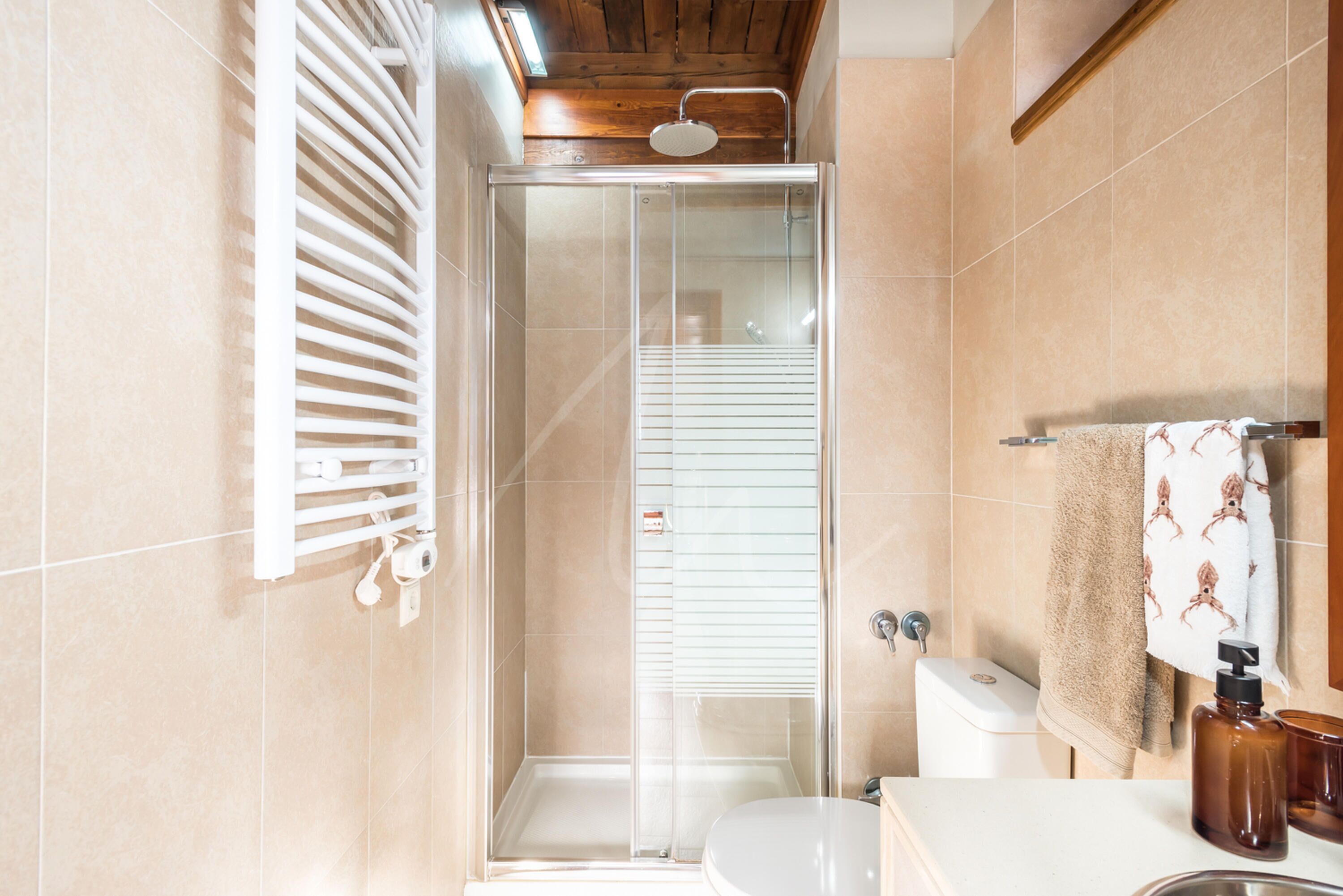 Une salle de bain moderne avec une douche à parois de verre, des toilettes et un lavabo équipé de produits de toilette.