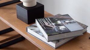 A wooden table with a stack of magazines, a white spherical object, and a black block. - Ideal 1 BR Apartment in Petralona (Athens)