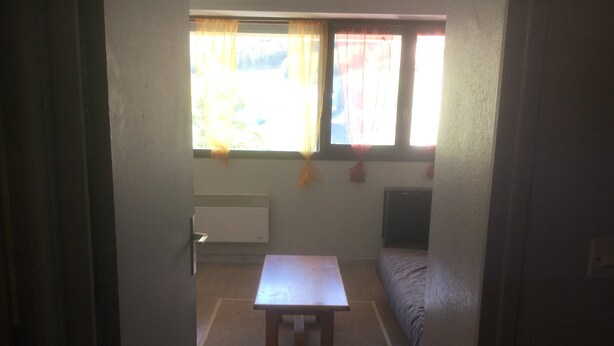 Ein Zimmer mit einem Bett, einem kleinen Tisch und einer Heizung.