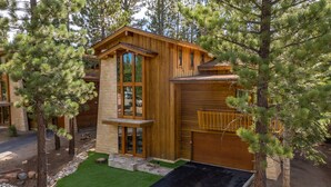 A wooden cabin with a stone facade, a balcony, and a small driveway. - Deluxe 5,000 sq. ft. Home, Hot Tub, Movie Theater, Gas Grill. On Golf Course (Mammoth Lakes)