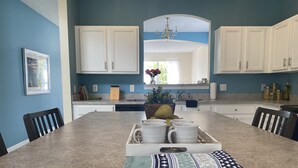 A kitchen with a central island, white cabinets, and a blue wall. - 7BR Family & Spacious Group Retreat!  Sleeps 14! Private Pool! 15 Min to Disney! (Kissimmee)