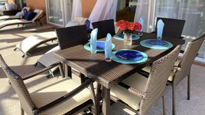An outdoor dining area with wicker furniture and blue plates. - 7BR Family & Spacious Group Retreat!  Sleeps 14! Private Pool! 15 Min to Disney! (Kissimmee)