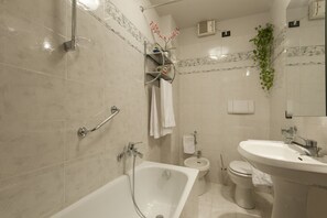 Tina con regadera, secadora de cabello, bidet, toallas 