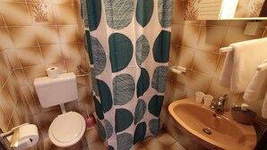 Un baño con inodoro, lavabo y cortina de ducha.