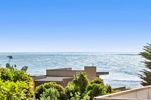 A coastal property with a view of the sea, featuring modern architecture and lush greenery. - Point Grey Apartment 7 (Lorne)