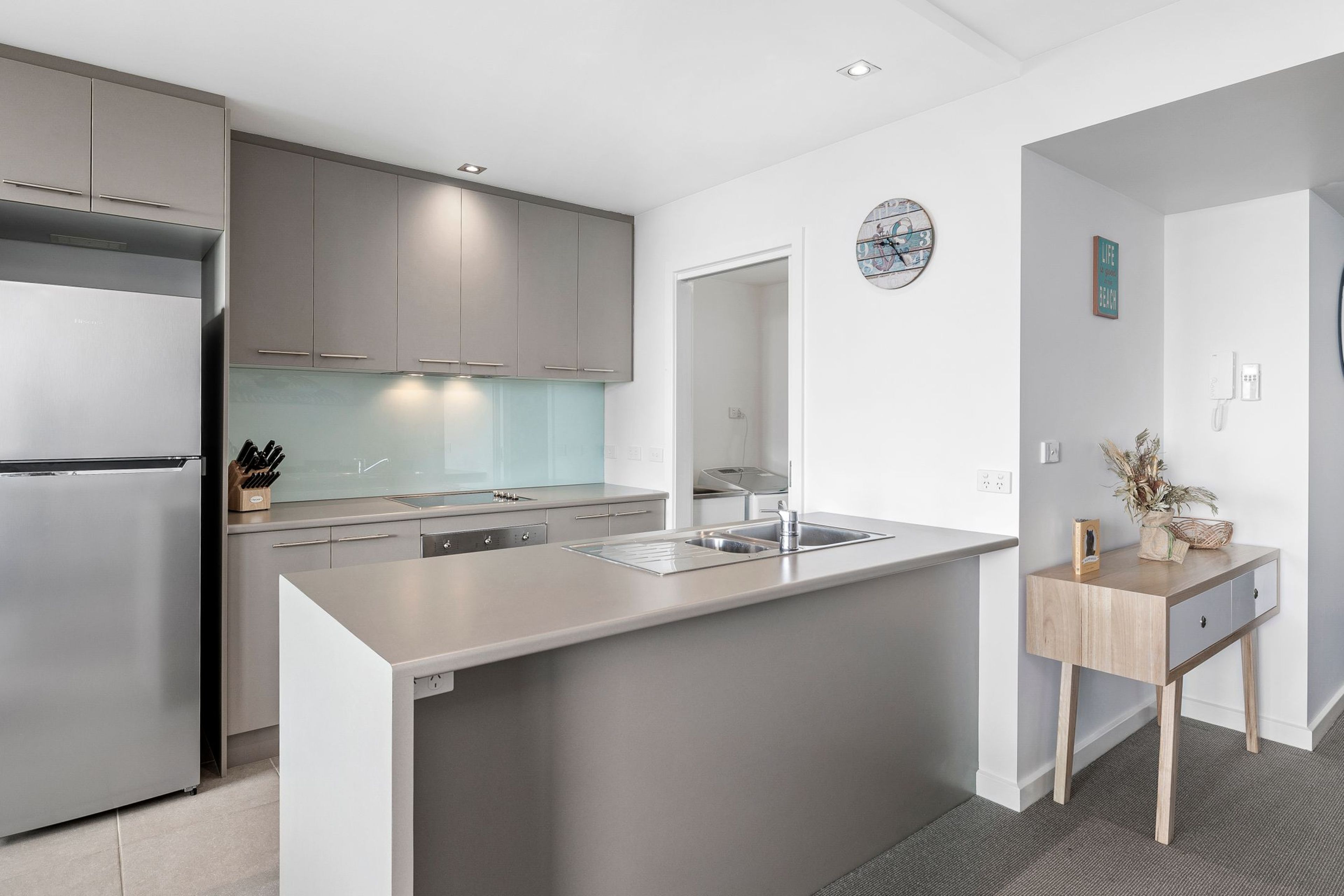 A modern kitchen with a built-in island, stainless steel appliances, and a minimalist design.