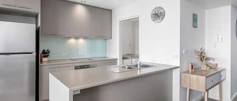 Una cocina moderna con una isla integrada, electrodomésticos de acero inoxidable y un diseño minimalista.