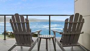 Two Adirondack chairs facing a view of the ocean with waves. - Oceania 3 (Lorne)