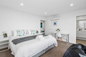 Une chambre moderne avec un lit, un bureau et un coin salon.