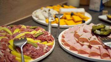 Een buffet met diverse gerechten, waaronder vleeswaren en kazen.
