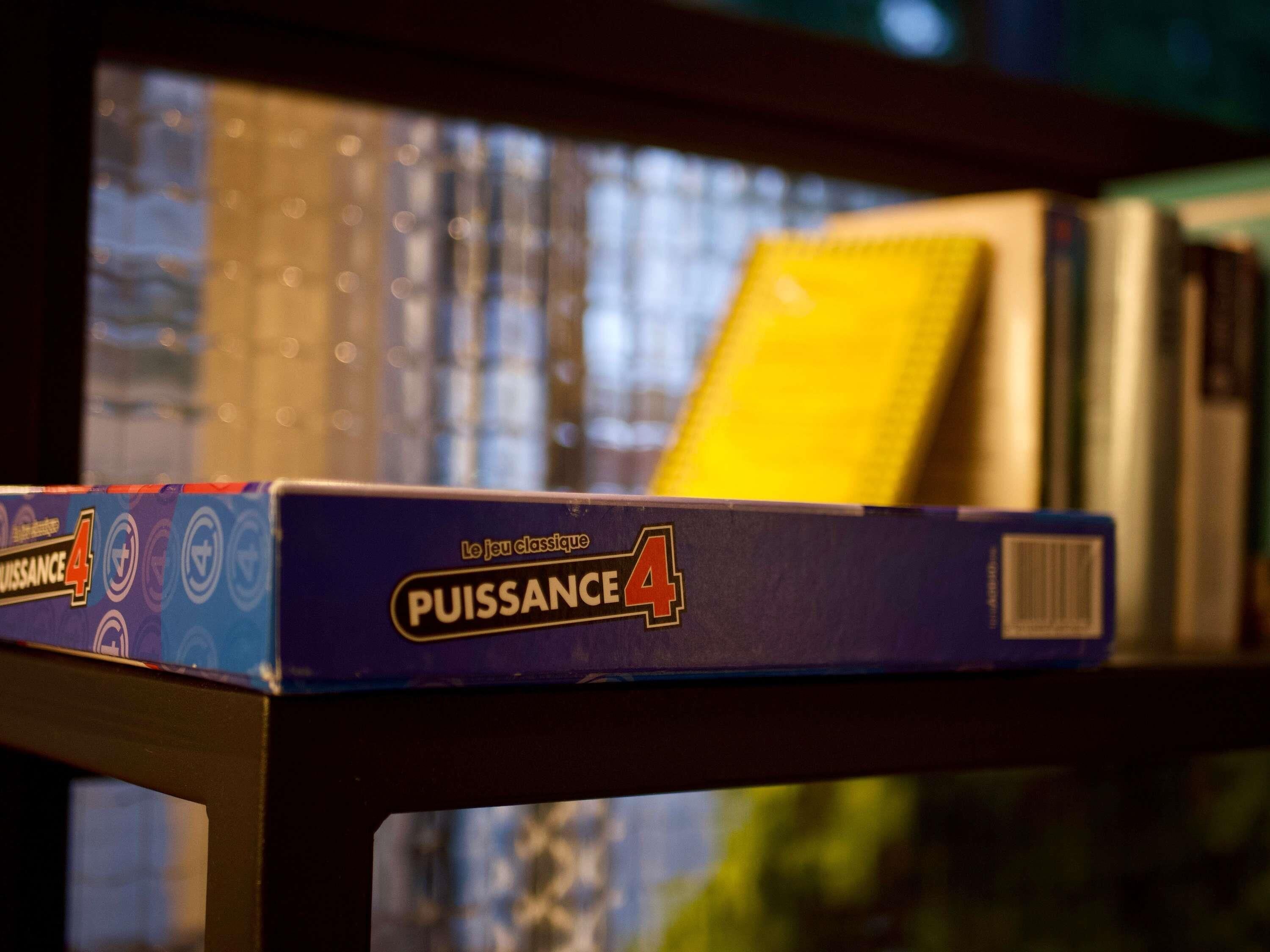 Un juego de mesa llamado 'PUISSANCE 4' en una estantería.