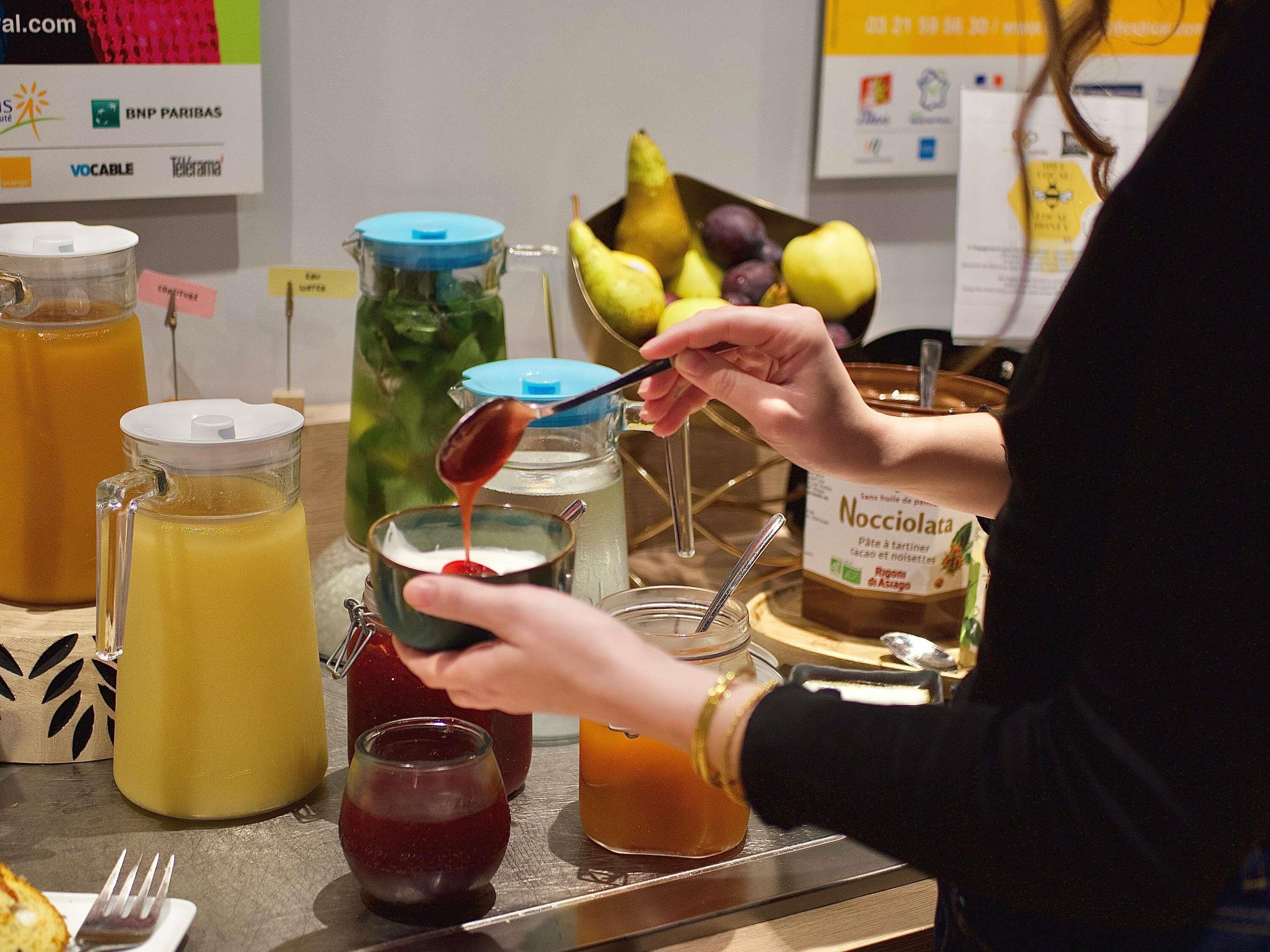 A person pouring a liquid from a jar into a cup.
