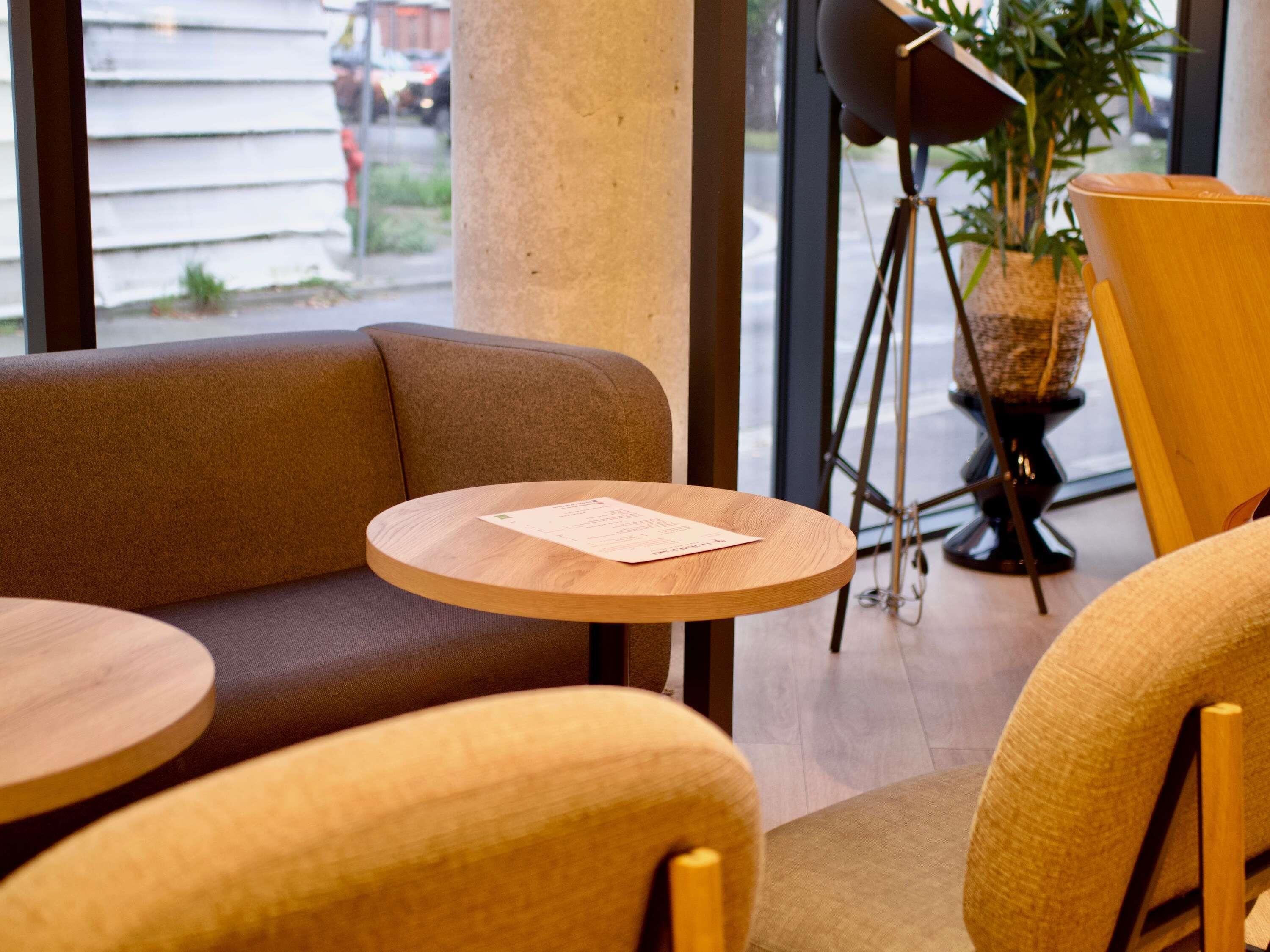 A seating area with a round wooden table and a sofa.