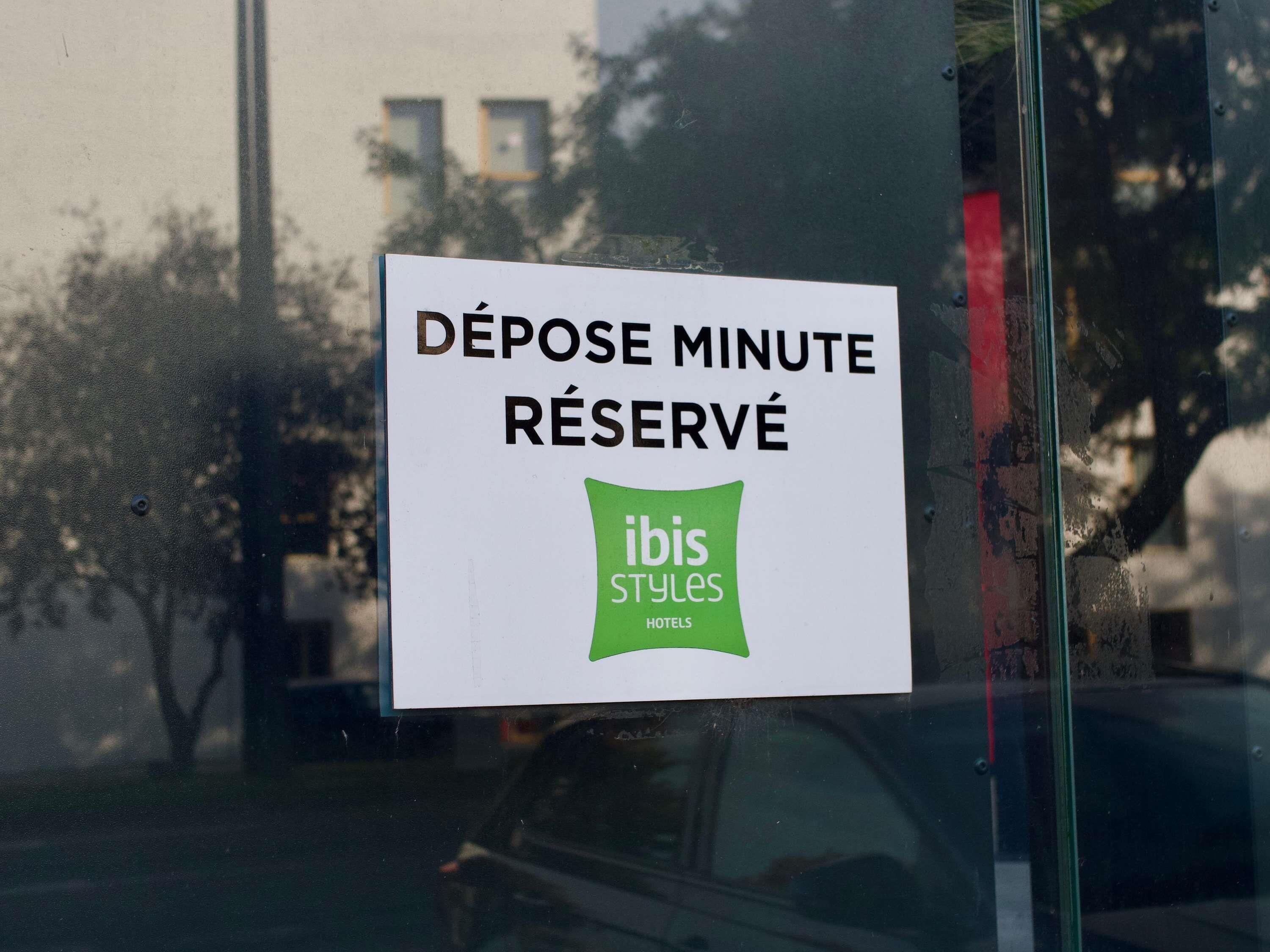 Placa na janela com 'DEPOSE MINUTE RÉSERVÉ' e 'ibis Styles HOTELS'.