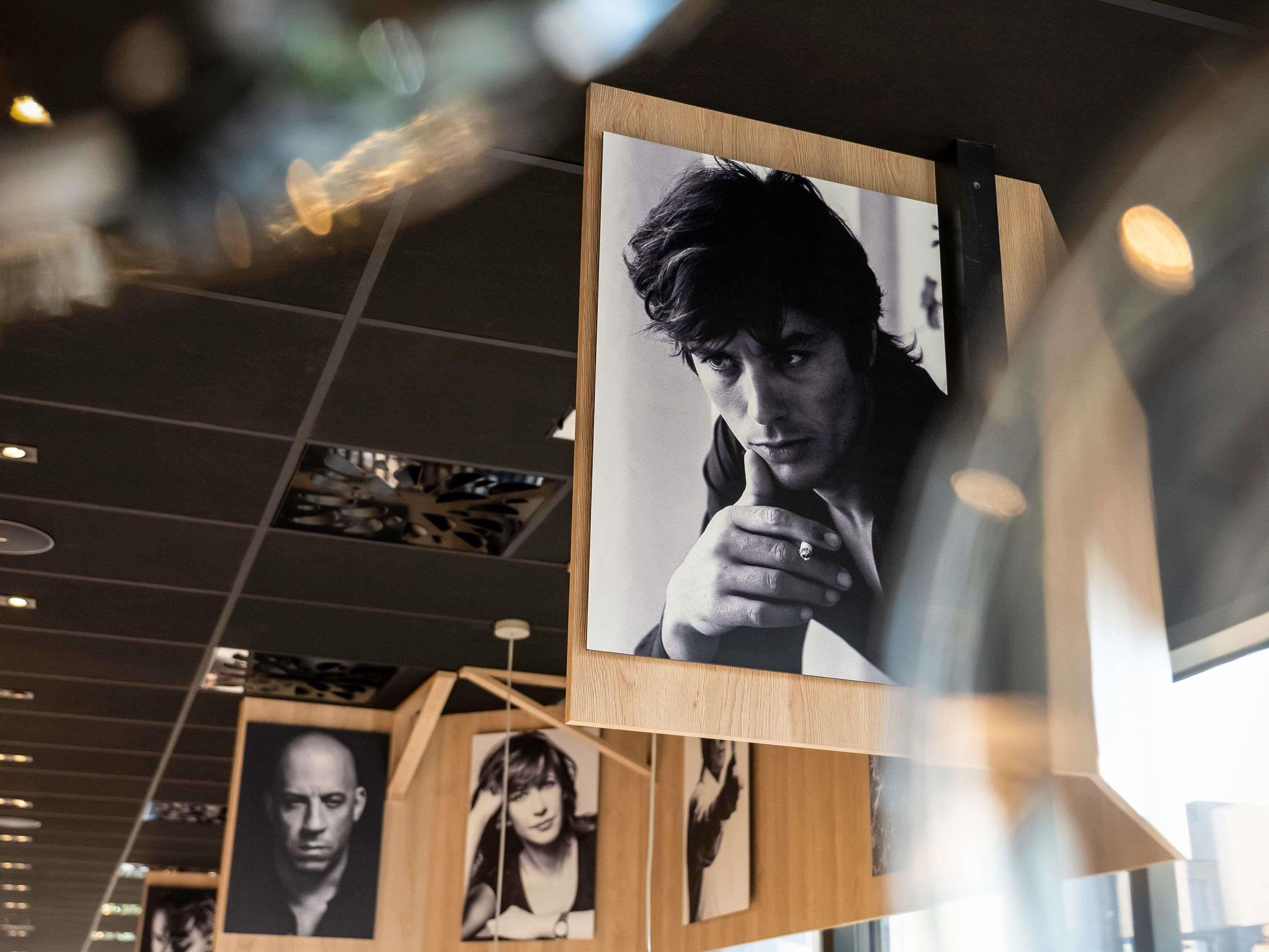 A wall with framed photographs and a wooden structure.