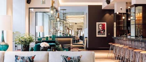 A modern interior with a sofa, bar area, and a large mirror.