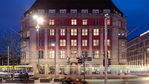A multi-story building with a prominent entrance, large windows, and a visible sign indicating a hotel. - Amerikalinjen (Oslo)