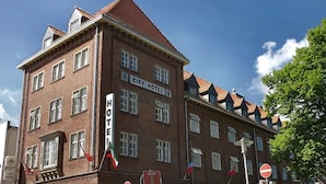 Ein mehrstöckiges Backsteingebäude mit einem Schild, das es als Hotel kennzeichnet.
