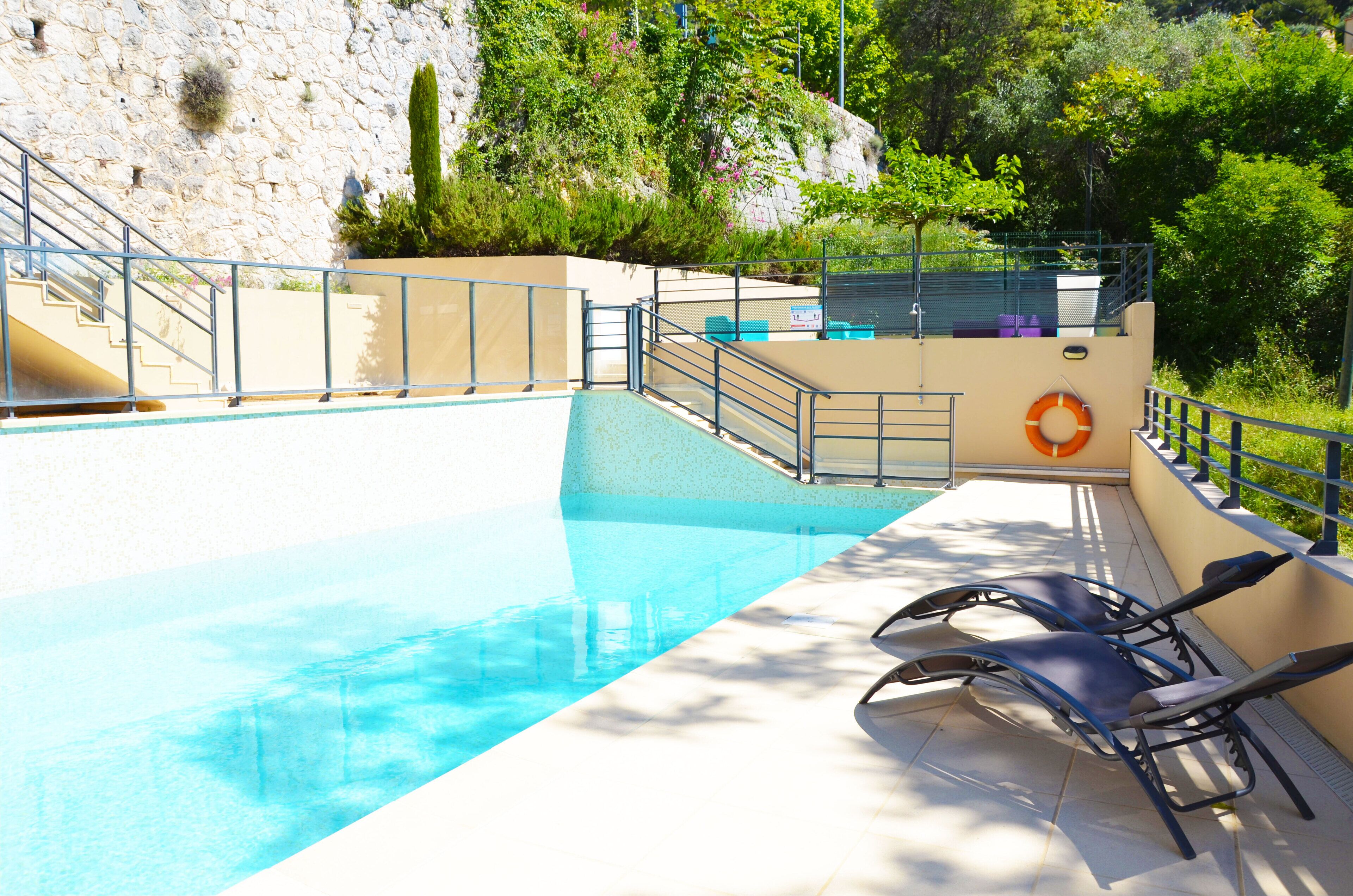 Una piscina amb un flotador, unes escales i gandules.