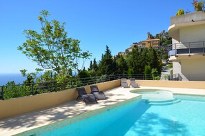 A rooftop pool with lounge chairs, a clear view of the sea, and buildings in the background. - La Perle d'Eze Appart Hotel (Èze)