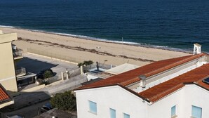 Una zona residencial costera con edificios, una playa y una vista despejada del océano.