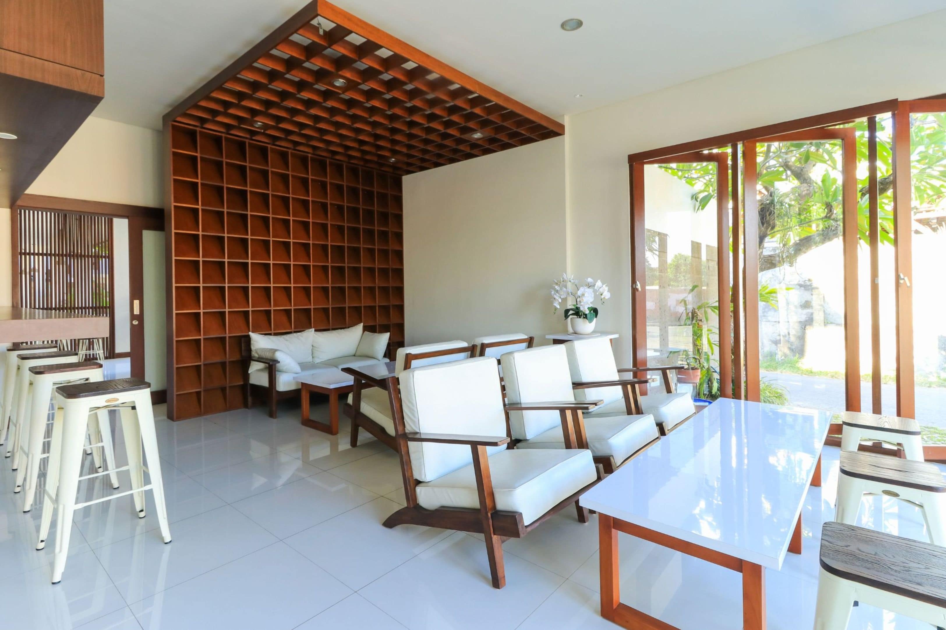 A modern interior with a dining area, seating, and a view through large glass doors.
