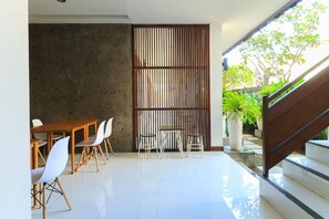 Un interior moderno con comedor, una escalera y vistas a zonas verdes.