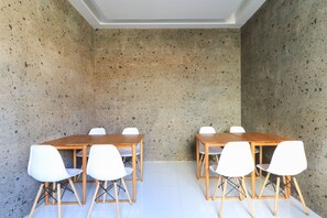 Une salle de conférence avec une longue table et six chaises blanches.