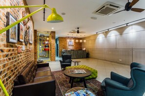 Ein stilvoller Lounge-Bereich mit Ledersitzmöbeln, einem Couchtisch und einer Rezeption.