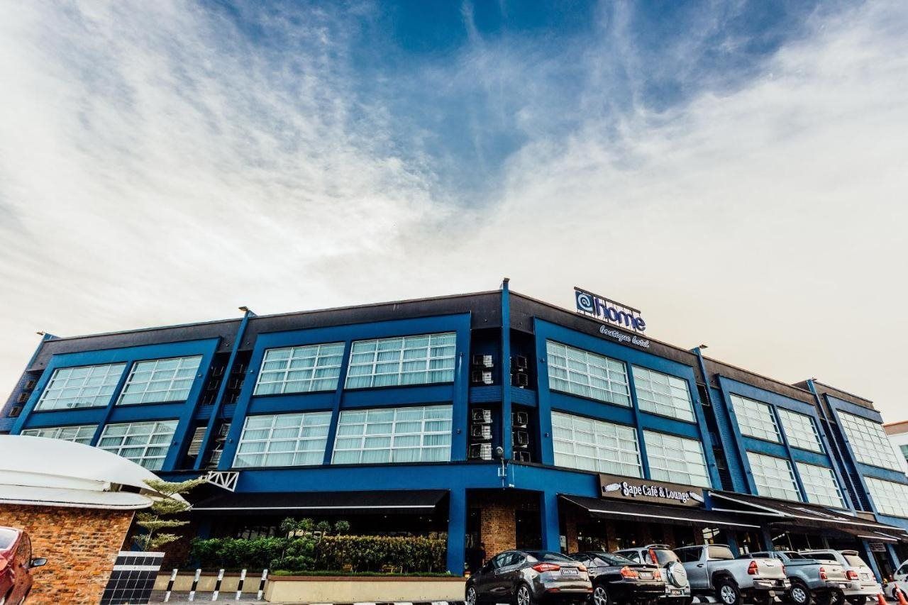 Un hotel con fachada azul, varias ventanas y un letrero que dice 'Sape Cafe & Lounge' en la planta baja.