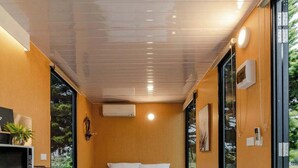 Ein kleines Schlafzimmer mit Bett, Nachttisch und einer kleinen Küchenzeile.