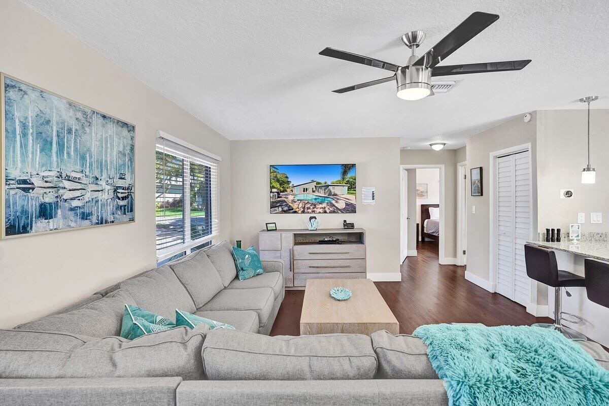 A living room with a sofa, coffee table, and artwork on the wall.
