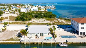 A coastal residential area with houses, a swimming pool, and a dock. - Waterfront, oceanview renovated pvt. 3 bedroom, 3.5 bath with pool and dockage. (Marathon)