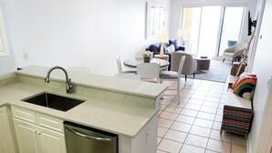 Una cucina moderna con lavastoviglie, lavello e zona pranzo con tavolo e sedie.