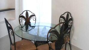 Une table ronde en verre, accompagnée de quatre chaises, chacune présentant un design métallique original.