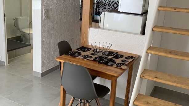 Een kleine keuken met een eethoek, een houten trap en een modern ontwerp.