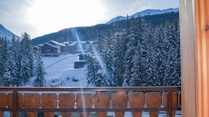 A snowy mountain landscape with a wooden balcony railing. - Hotel Milano (Valfurva)
